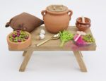 Mesa pequeña partiendo y aliñando aceitunas. Medidas: 12x5x5cm.